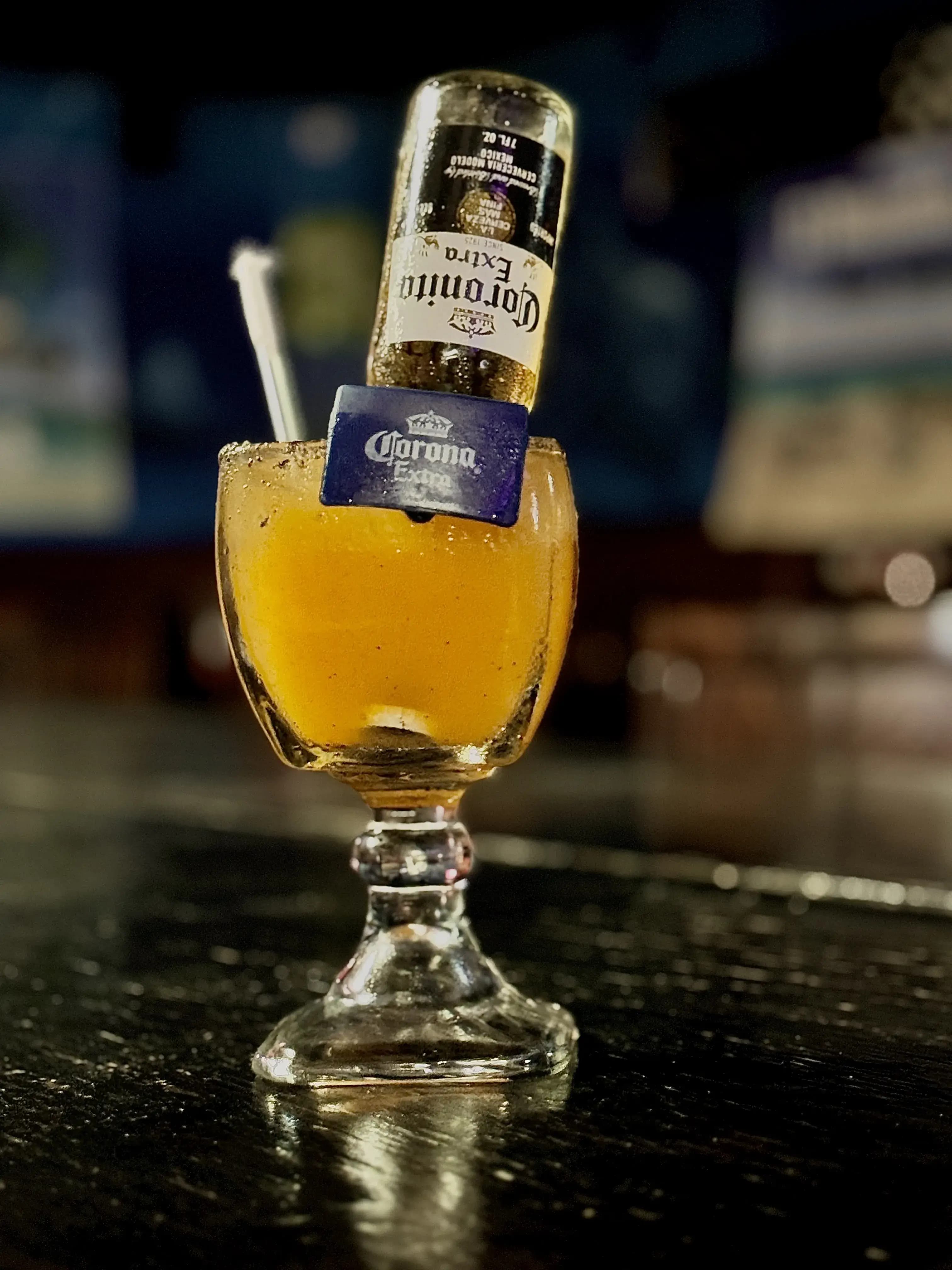 Margarita similar style drink called a Margarona. A glass chalice with an upside-down corona sitting in the yellow and ice-cold drink.